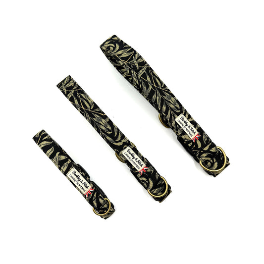 Three black dog collars with gold leaf pattern on a white background