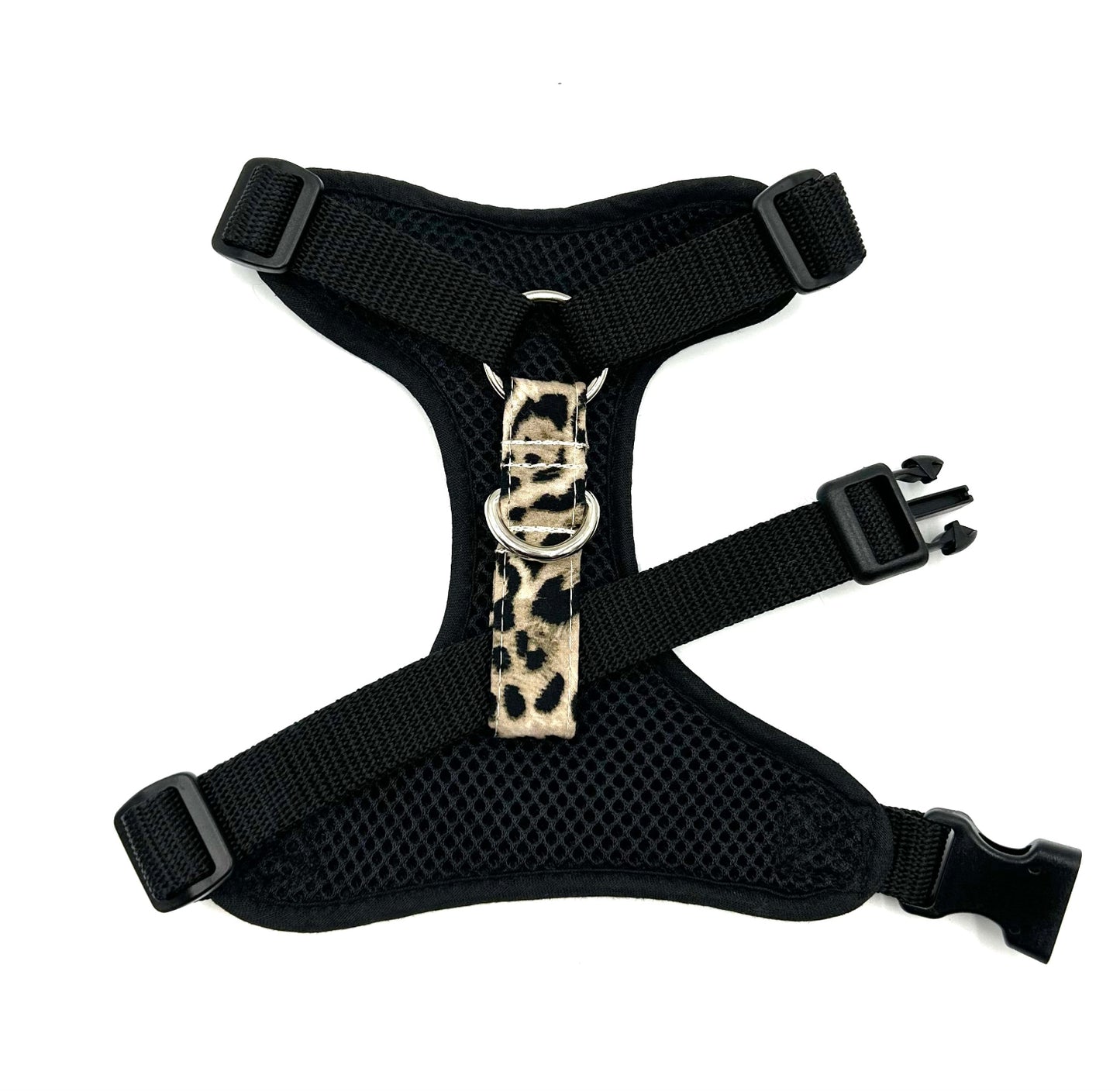 Black dog harness with a leopard print buckle on a white background