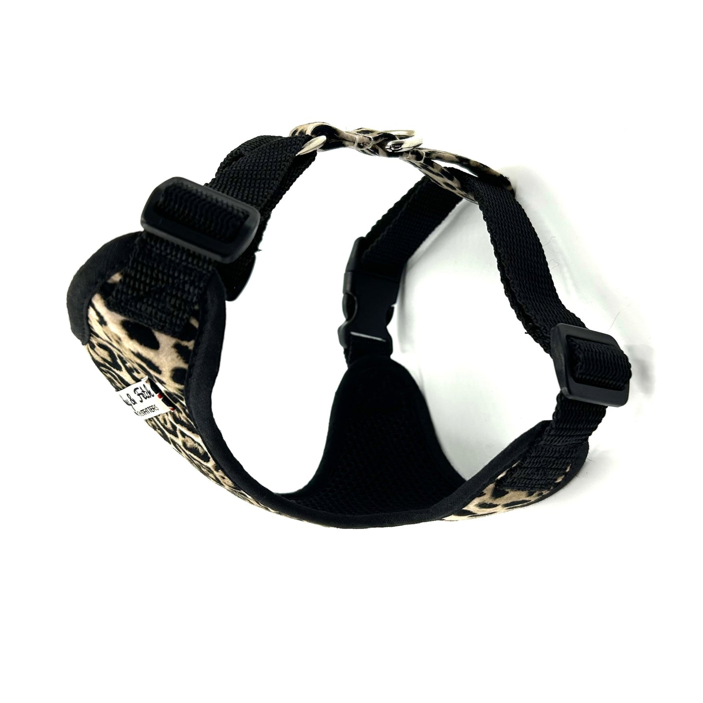 Black dog harness with leopard print design on a white background
