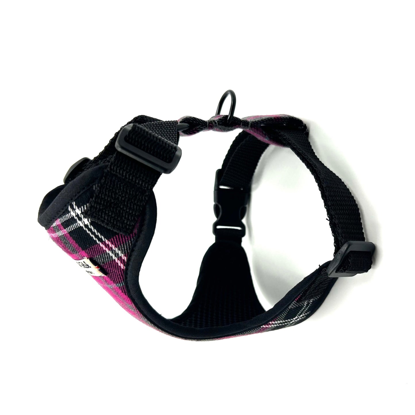 Black dog harness with pink plaid pattern on a white background