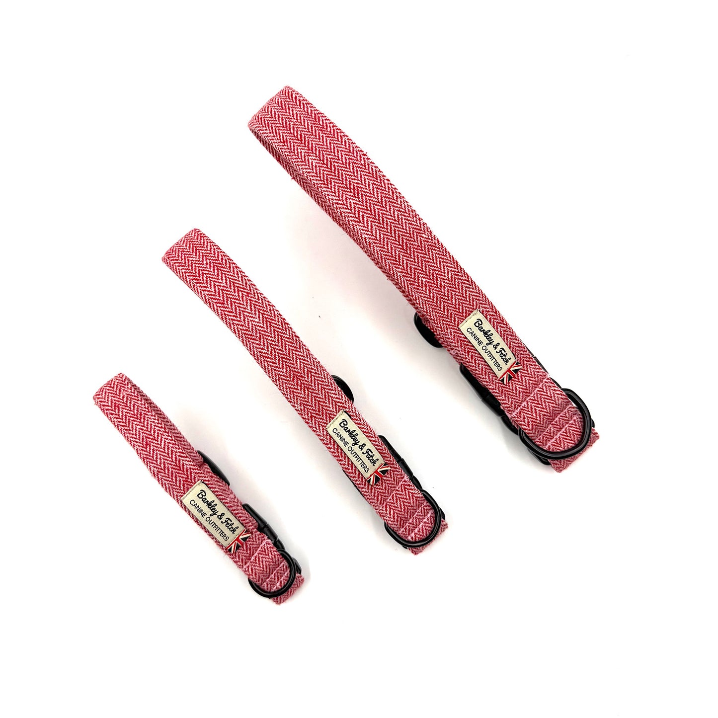 Three red herringbone-patterned dog collars with black hardware on a white background.