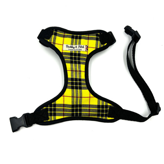 A yellow tartan pattern dog harness with black straps and a side release buckle.