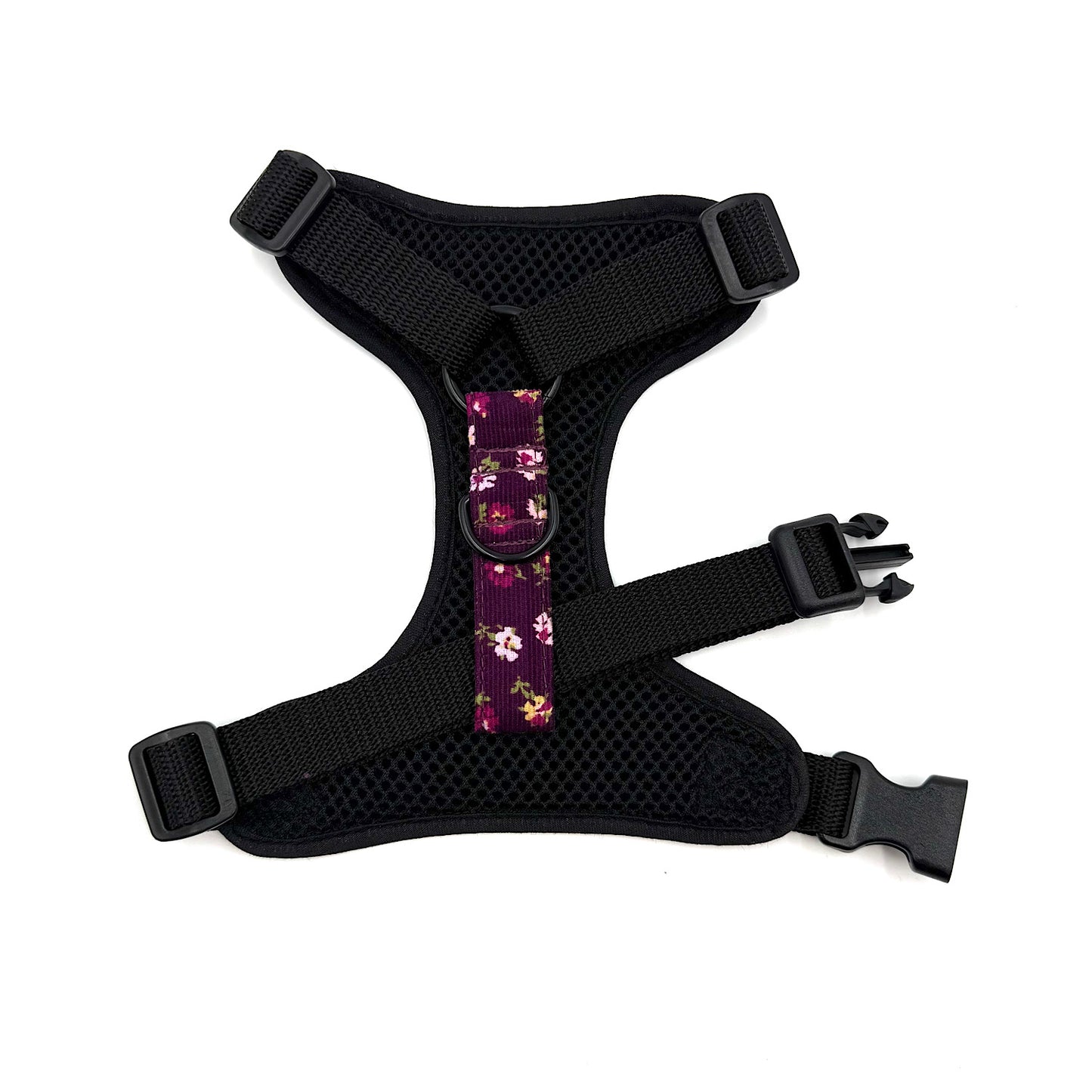 Black dog harness with floral pattern on a white background