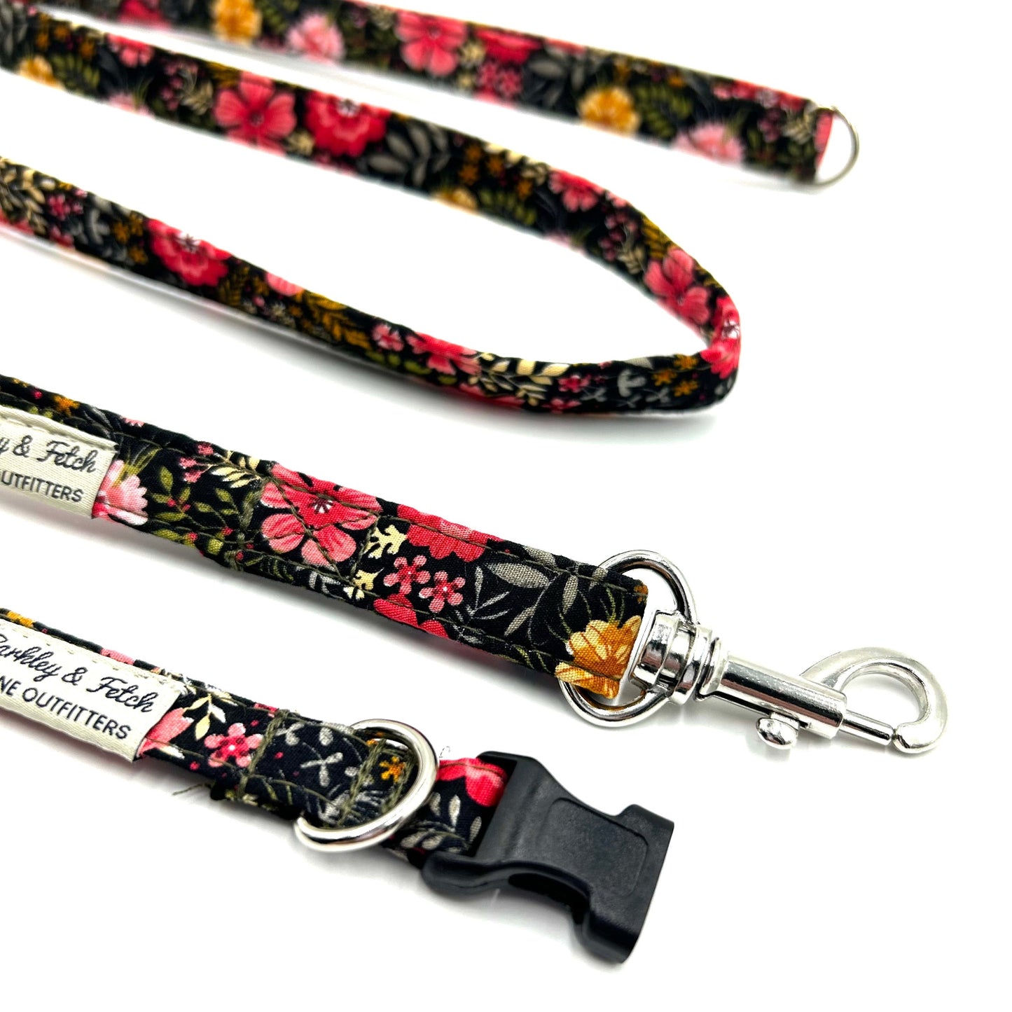 Floral patterned dog leash with metal clip on a white background