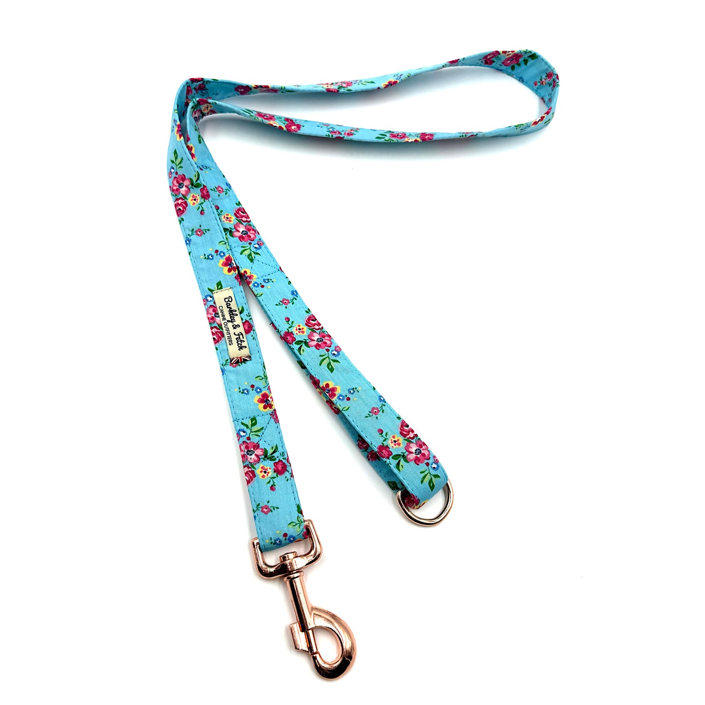 Floral patterned dog leash with rose gold clip on a white background