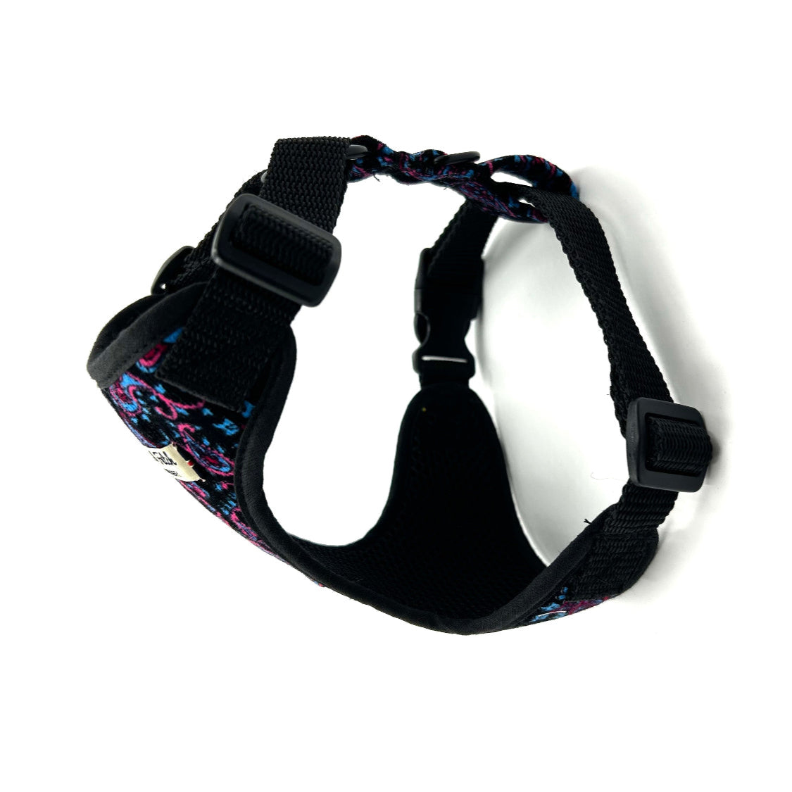 Black dog harness with colorful floral pattern on a white background