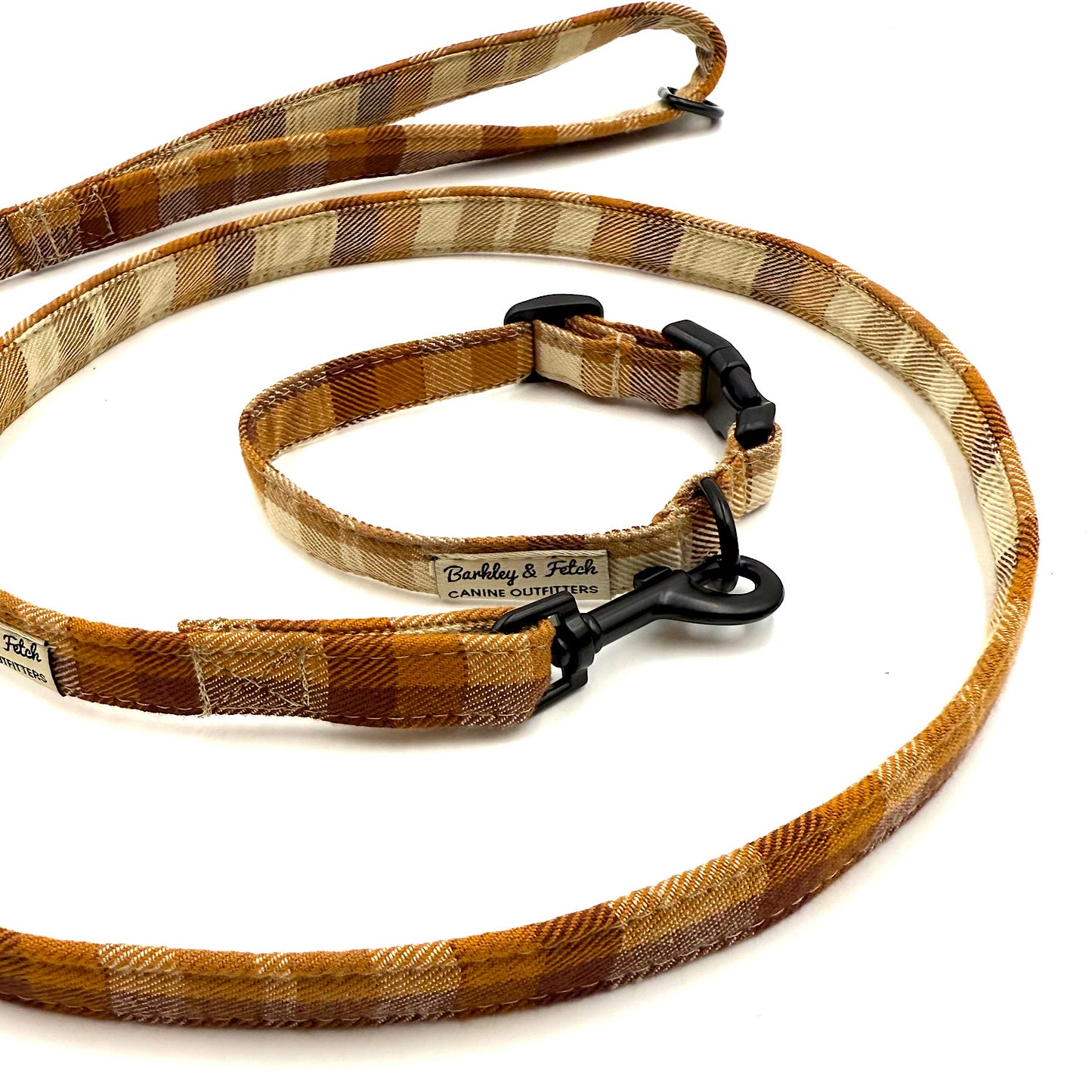 Brown plaid dog leash with black clip on a white background