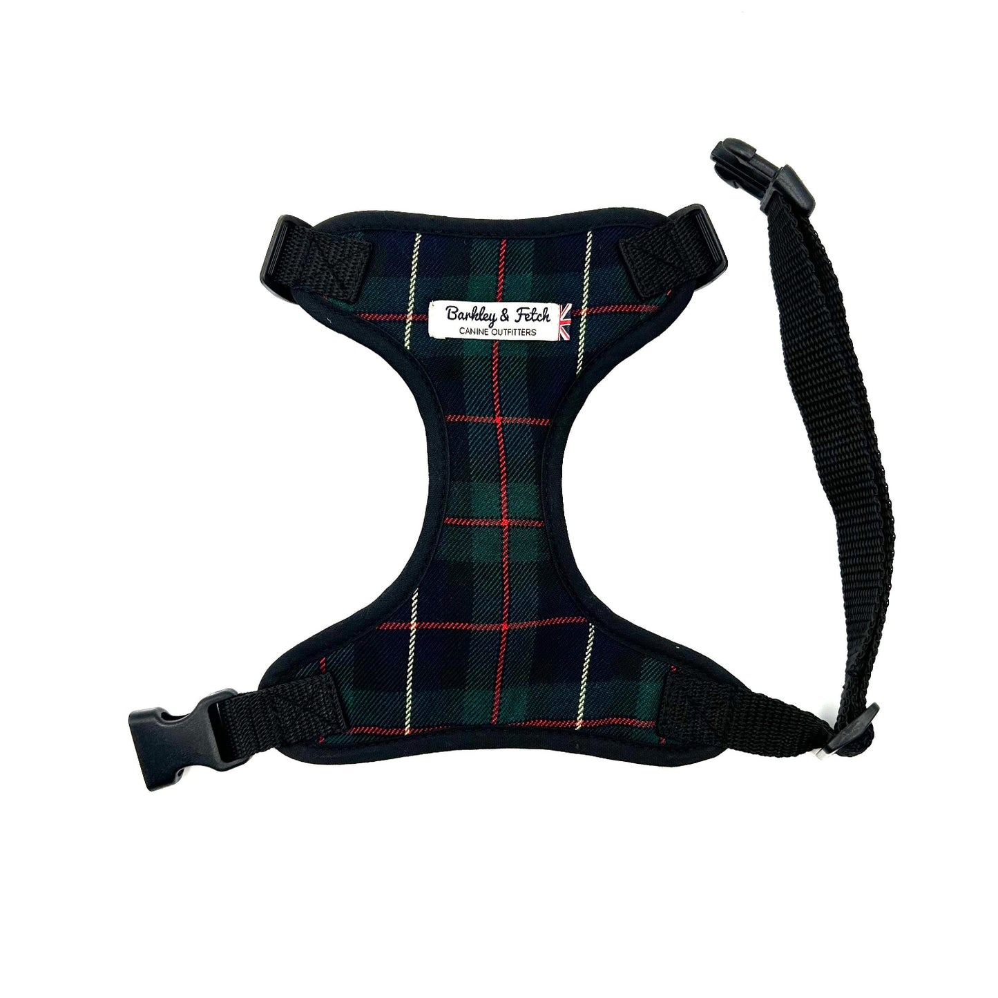 A green and navy tartan fabric dog harness with adjustable straps and a metal D-ring, displayed on a white background.