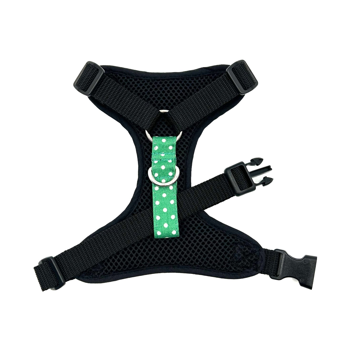 Black dog harness with a green polka dot strap on a white background