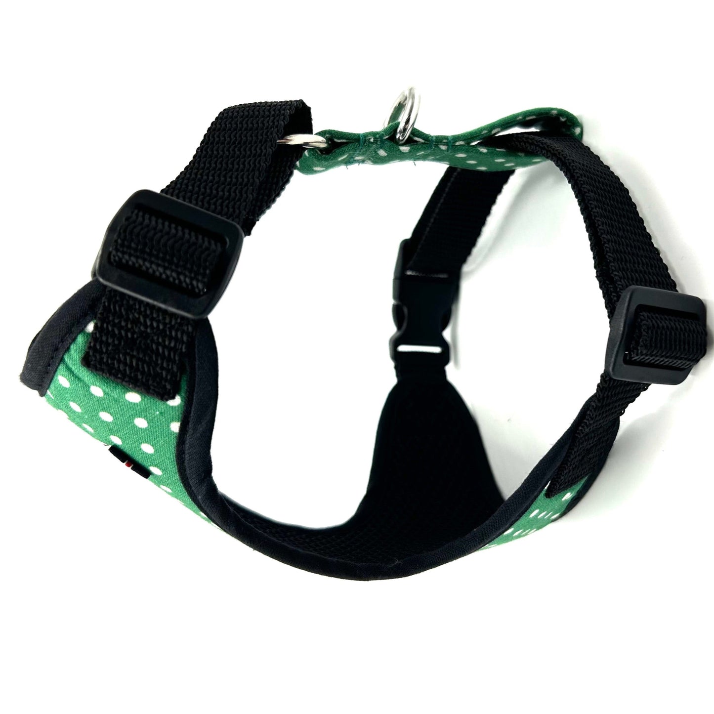 Green and black dog harness with polka dot pattern on a white background