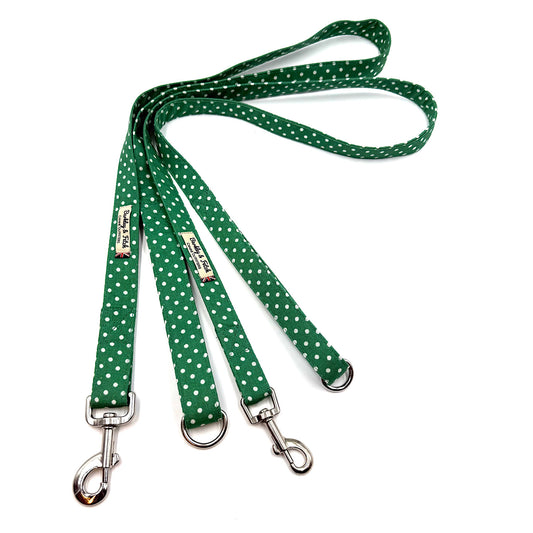 Green polka dot dog leash with metal clips on a white background