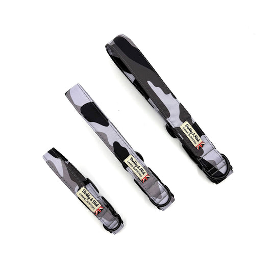 Three black and gray camo print dog collars with visible branding on a white background