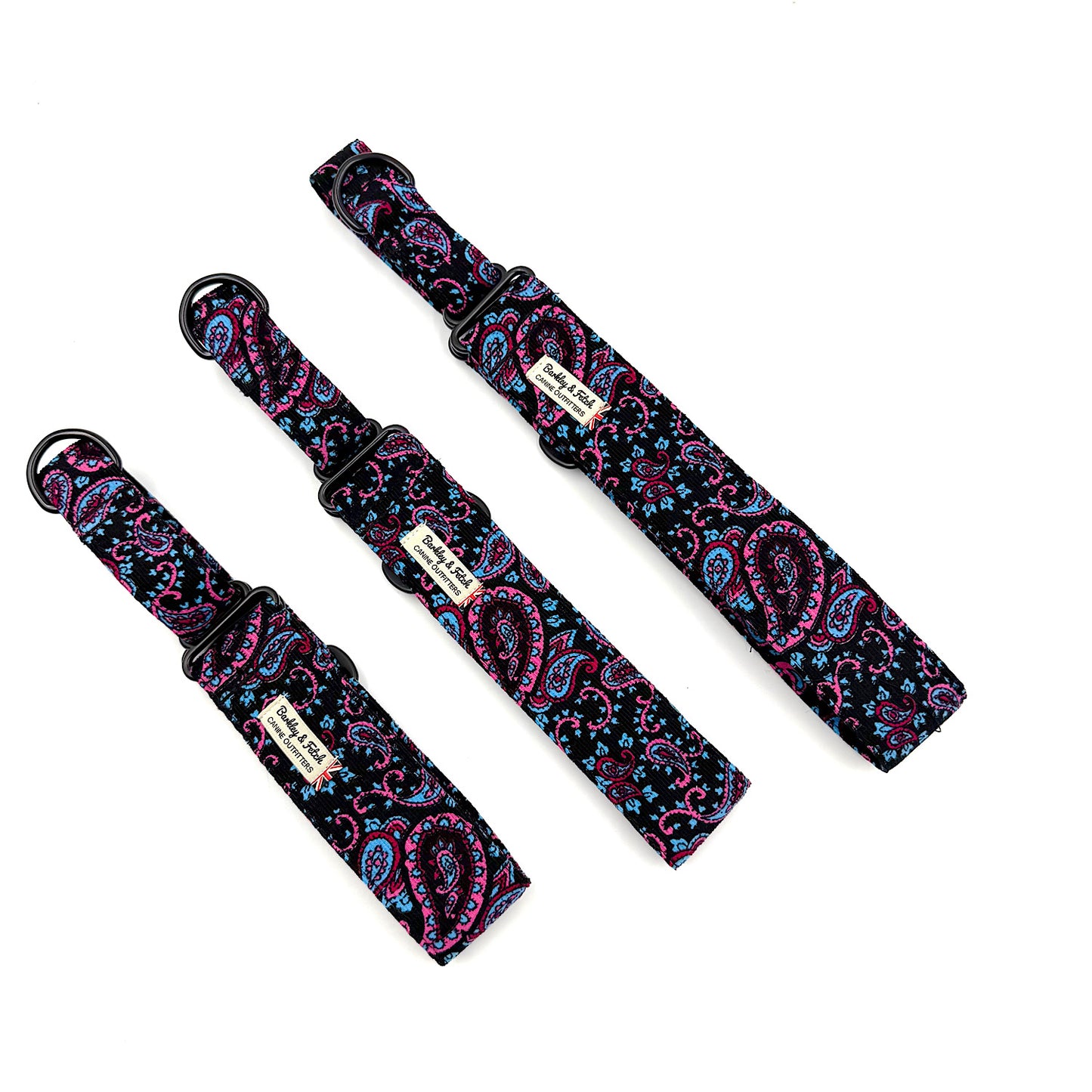 Three black dog collars with pink and blue paisley patterns on a white background