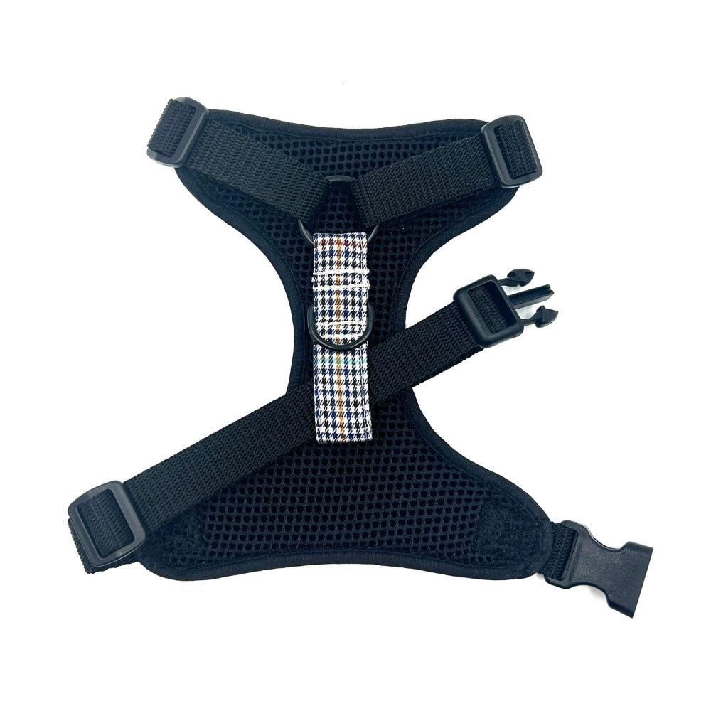 Black dog harness with a checkered strap on a white background