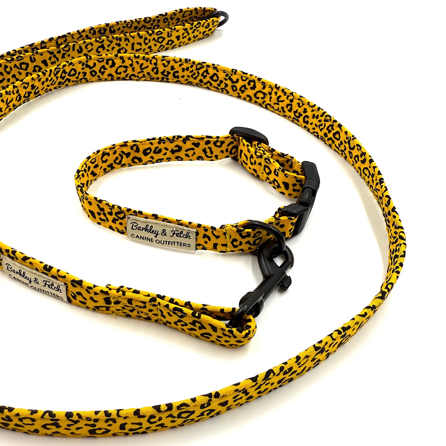Yellow and black leopard print dog leash with a black clip on a white background