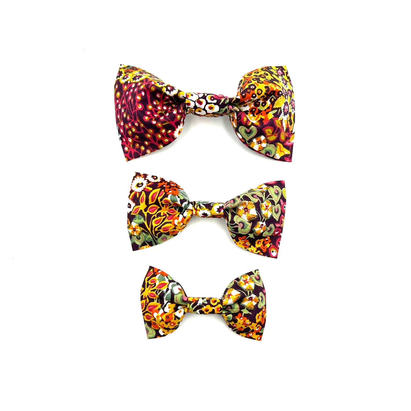 Three colorful floral-patterned hair bows on a white background