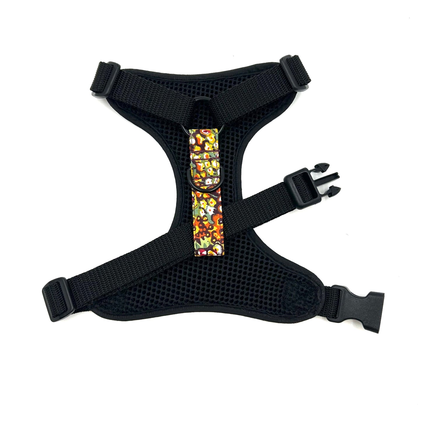 Black dog harness with colorful decorative strap on a white background