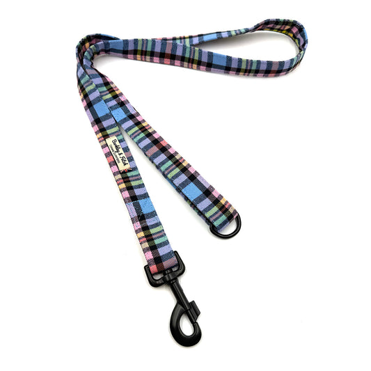 Plaid dog leash with a black clip on a white background
