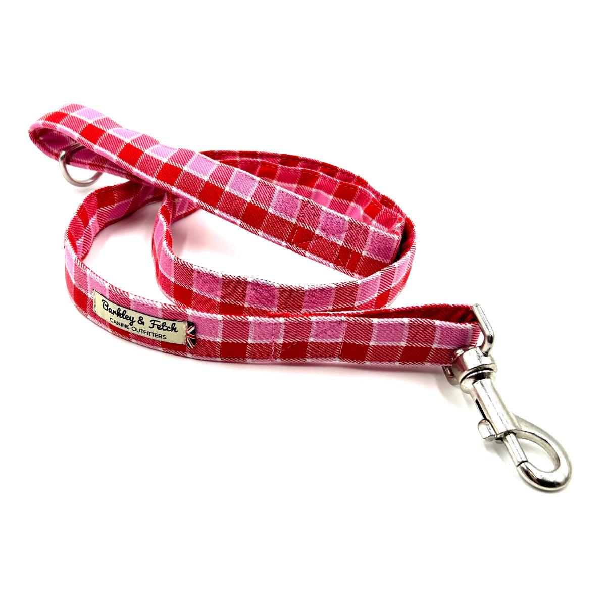Red and pink checkered dog leash with a metal clip on a white background