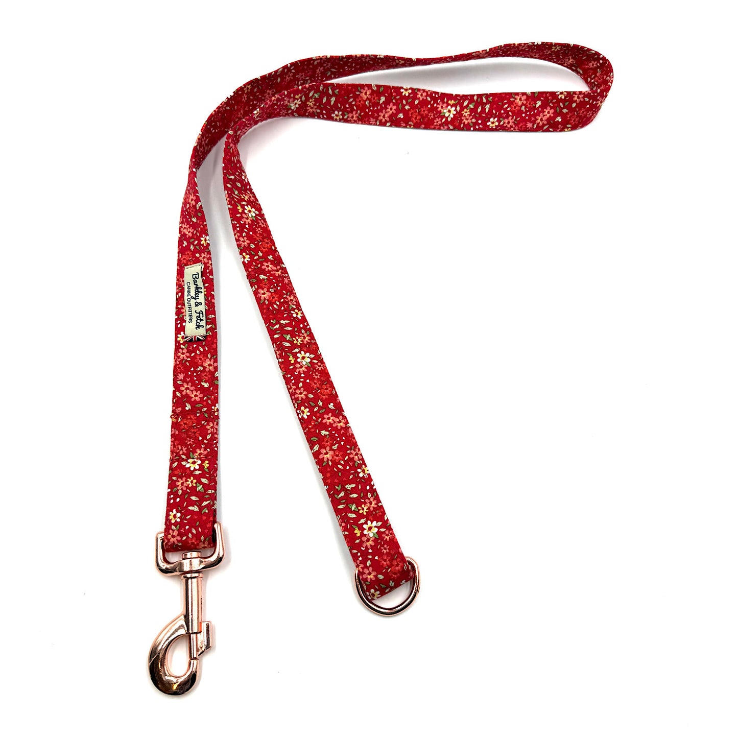 Red floral print dog leash with rose gold clip on a white background