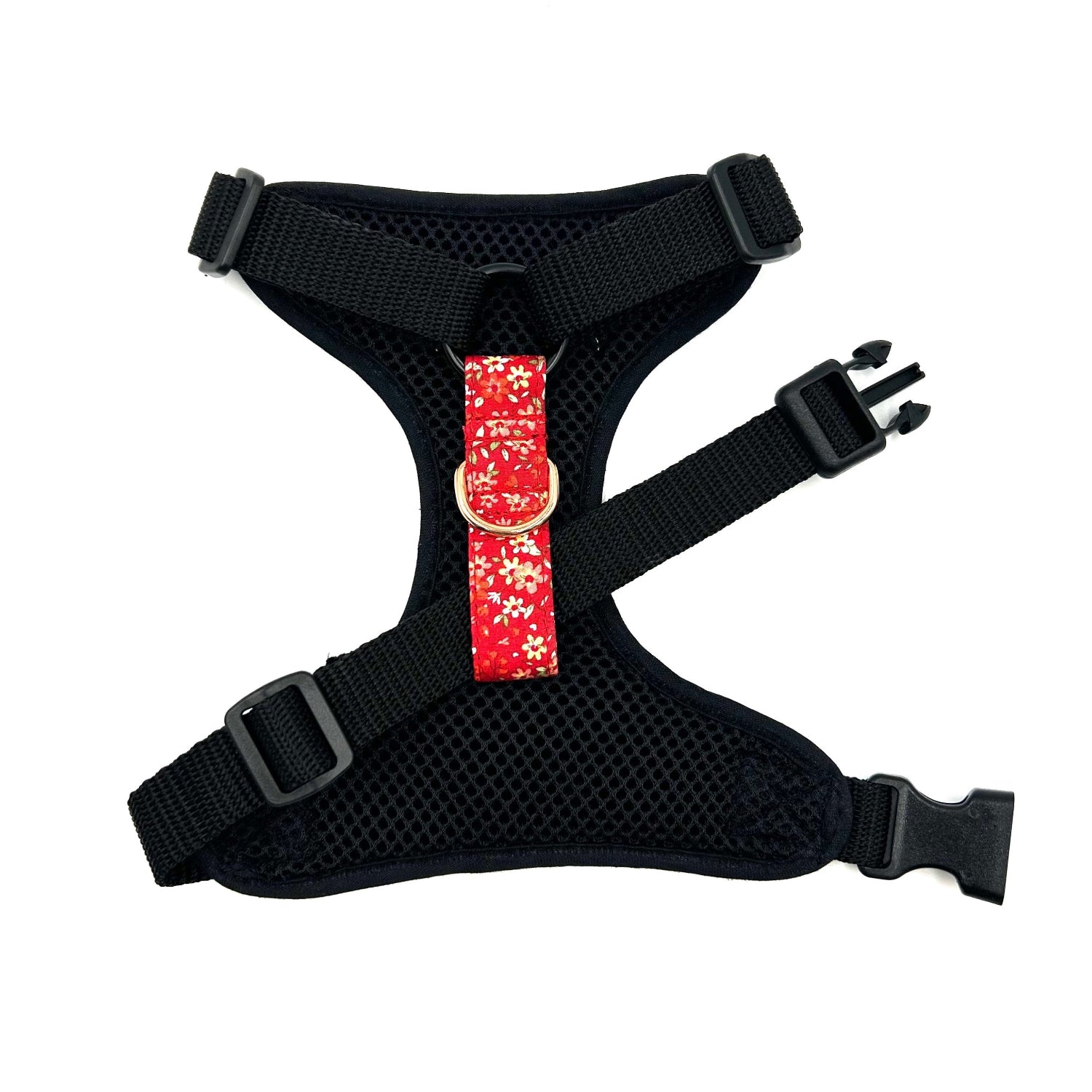 Black dog harness with a red floral strap on a white background
