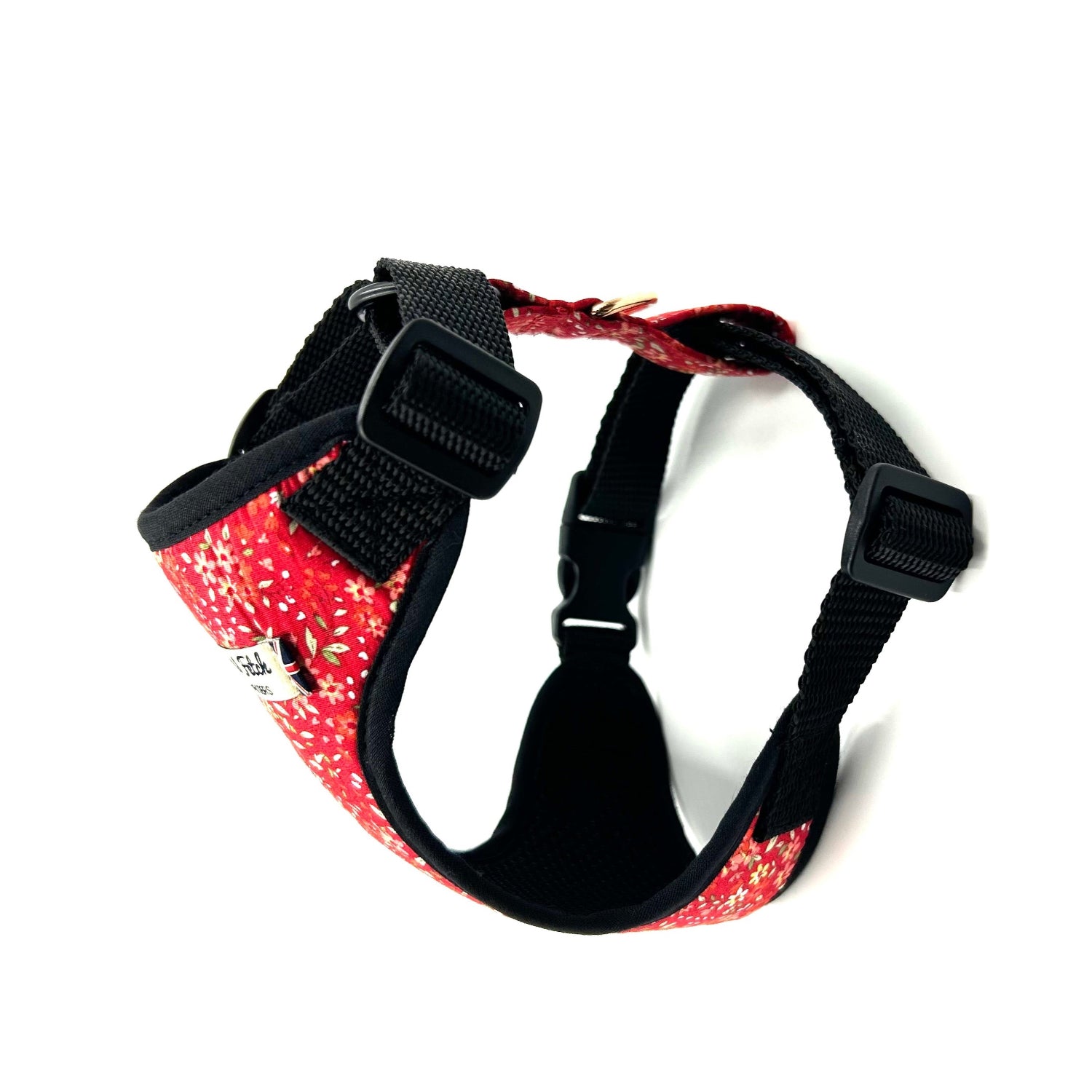 Dog harness with red floral pattern and black straps on a white background
