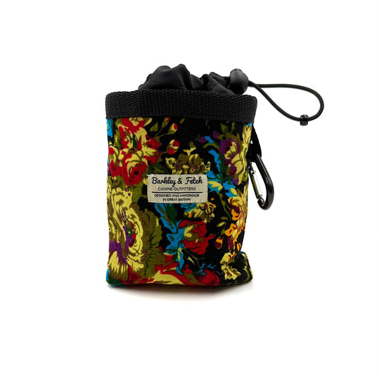 Colorful drawstring pouch with floral pattern and brand label on a white background