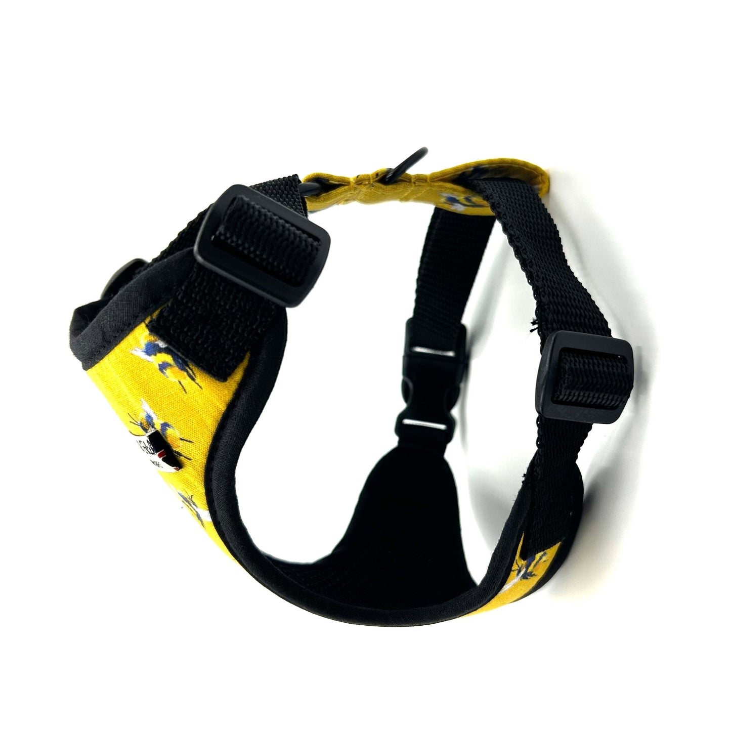 Yellow dog harness with black straps on a white background