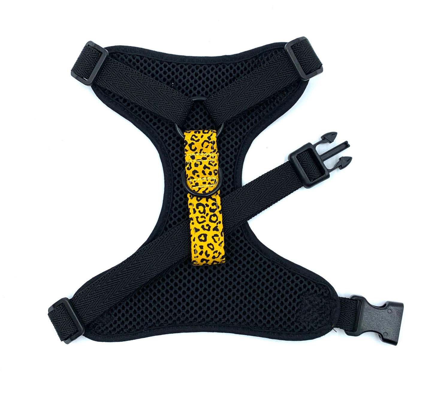 Black dog harness with a yellow leopard print strap on a white background