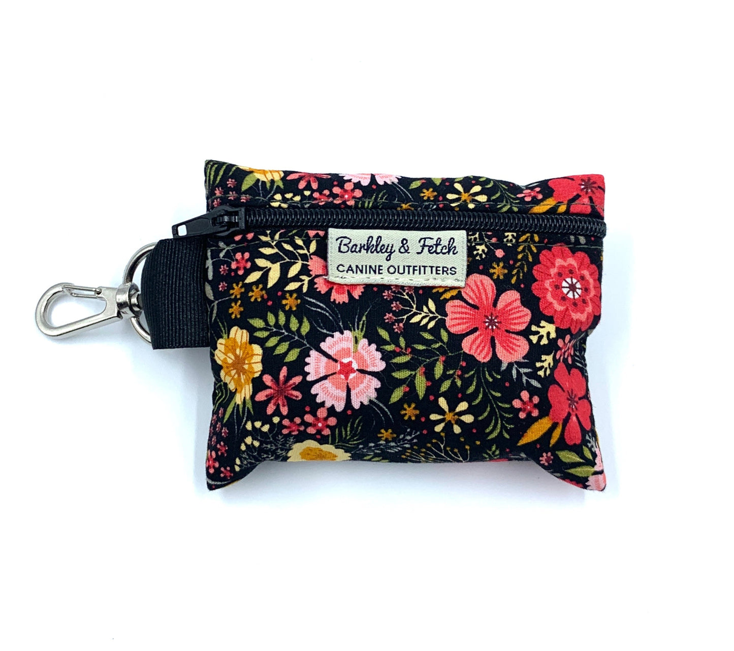 A floral print poo bag holder with a label that reads 'Barkly & Fetch'. It has a keyring attachment and is primarily black with colorful flower patterns.