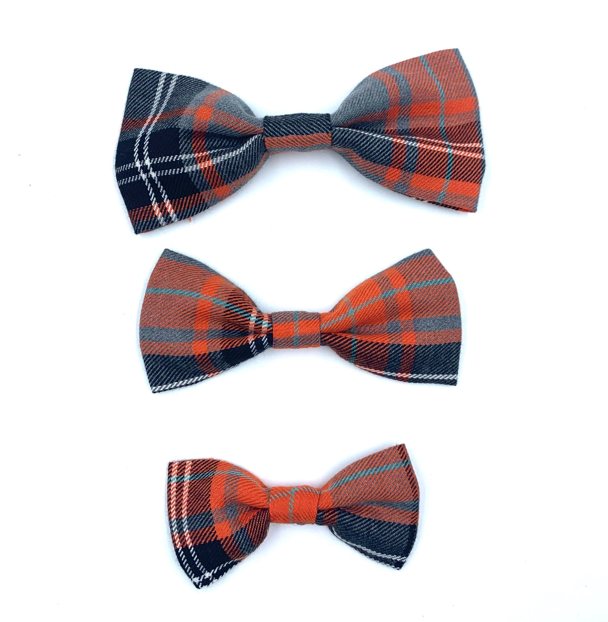 Three plaid bow ties in orange, blue, and red on a white background