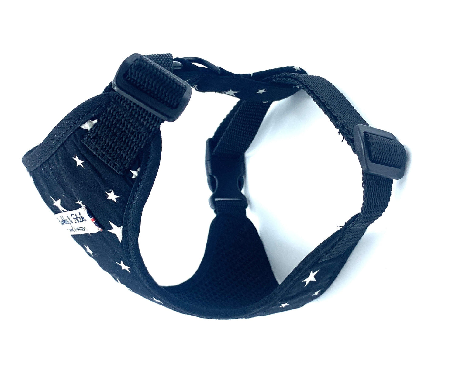 black dog harness with white star pattern on a white background