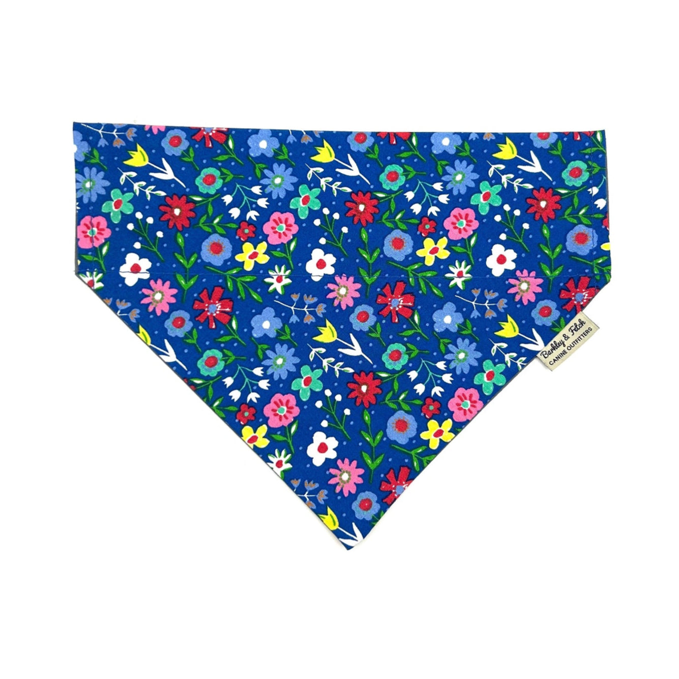 A cobalt blue floral print dog bandana with various colors of flowers on it.