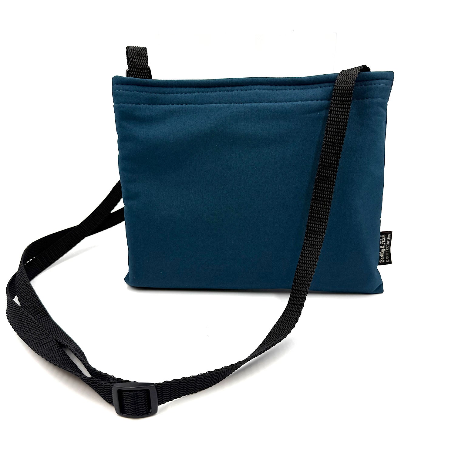 Teal colour settle mat folded into a velcro closed bag with a black shoulder strap handmade by Barkley and fetch in the UK, against a white background
