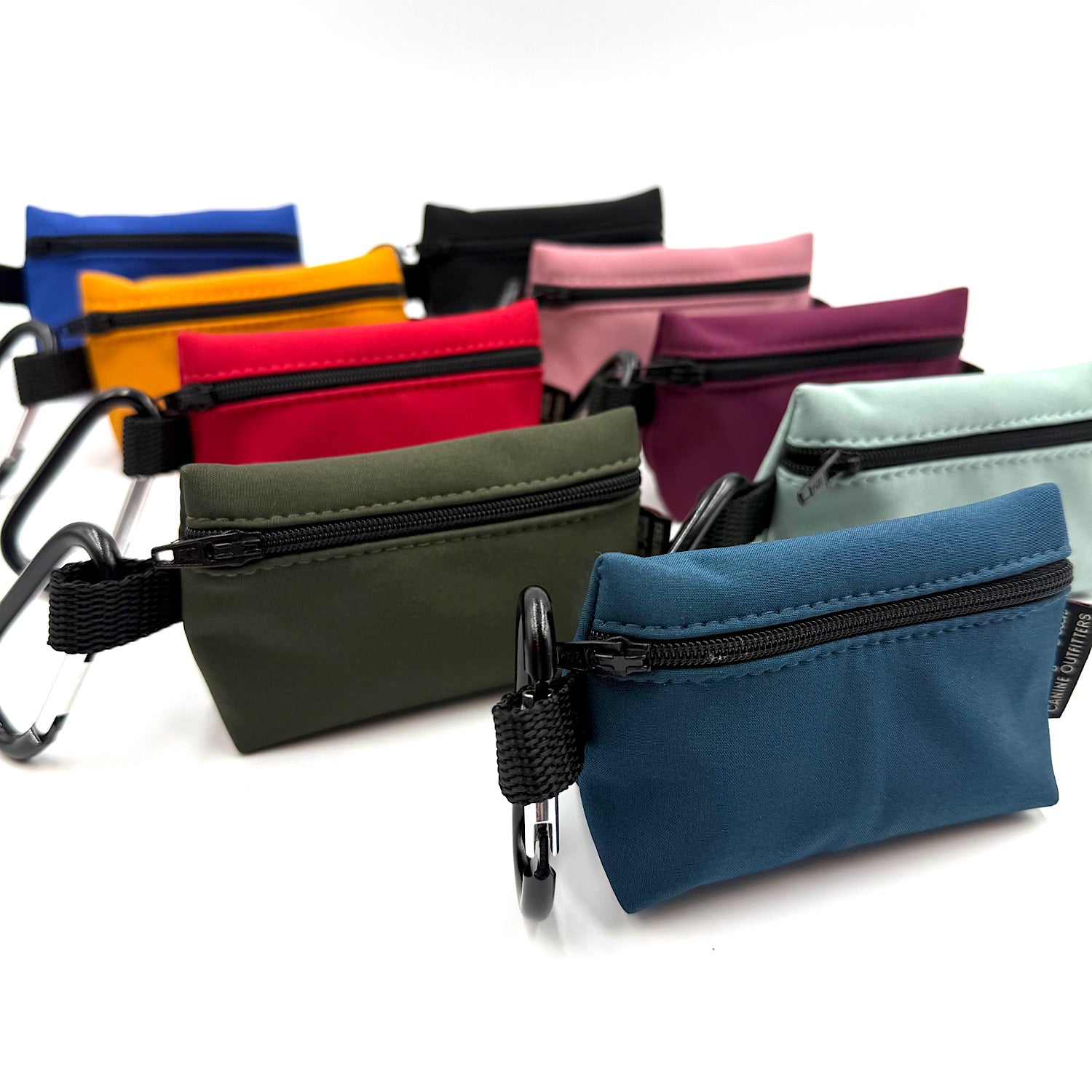 Assorted colourful small poo bag pouches with zippers on a white background handmade by Barkley and Fetch UK