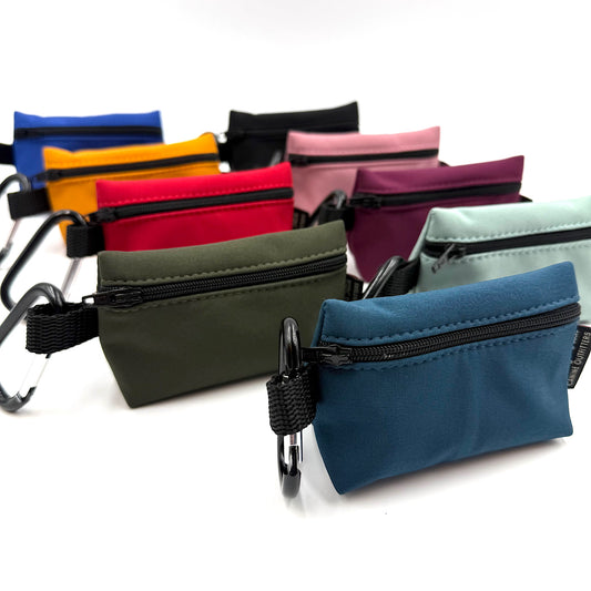 Assorted colourful small poo bag pouches with zippers on a white background handmade by Barkley and Fetch UK