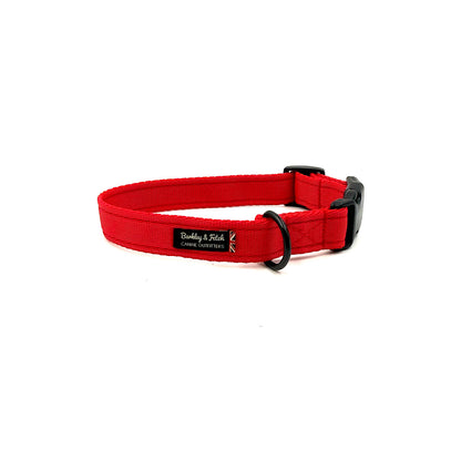 Red dog collar with a black buckle on a white background