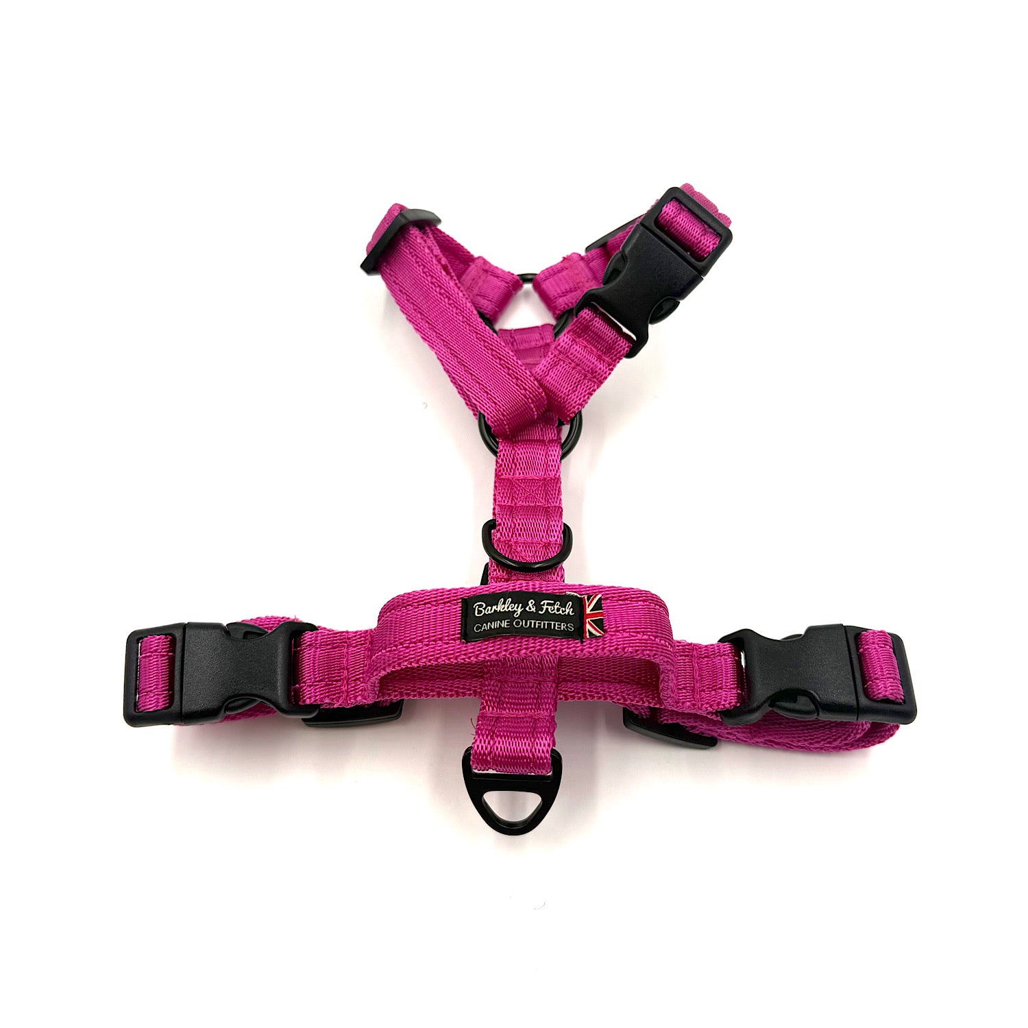 Pink dog harness with black buckles on a white background