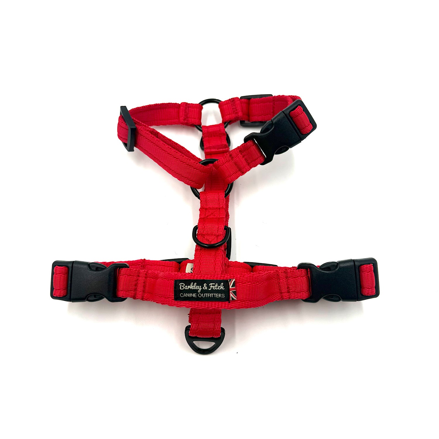 Red dog harness with black buckles on a white background