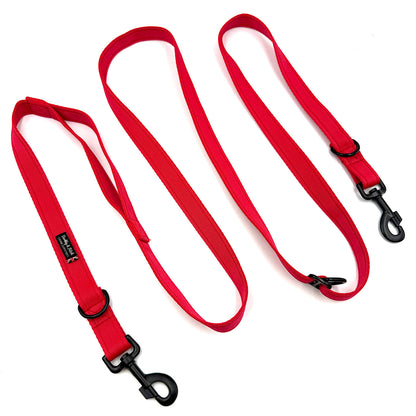 Red dog leash with black clips on a white background