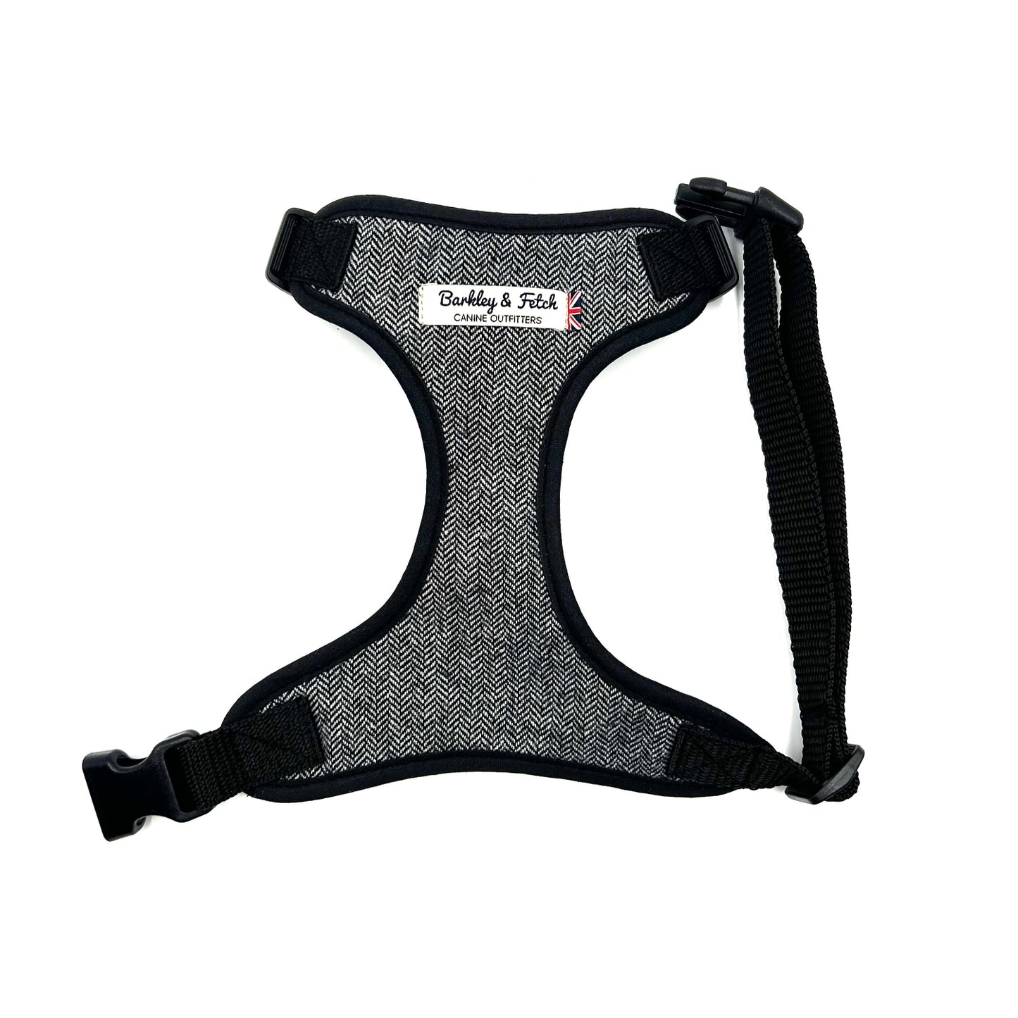 A grey herringbone pattern dog harness with adjustable straps and a heavy-duty d-ring, displayed on a white background.