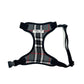 A grey and white tartan dog harness with adjustable straps, a side release buckle, and a visible brand label.