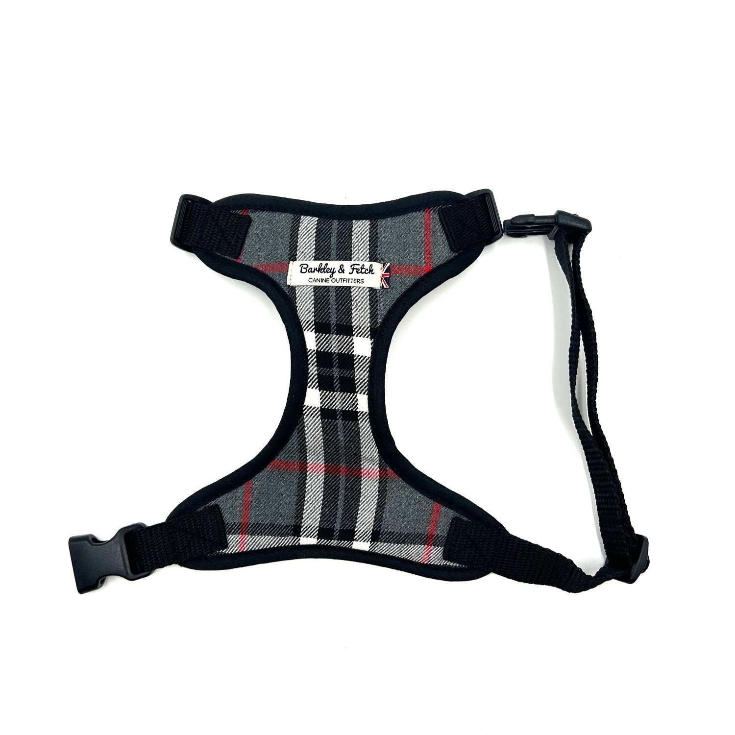 A grey and white tartan dog harness with adjustable straps, a side release buckle, and a visible brand label.