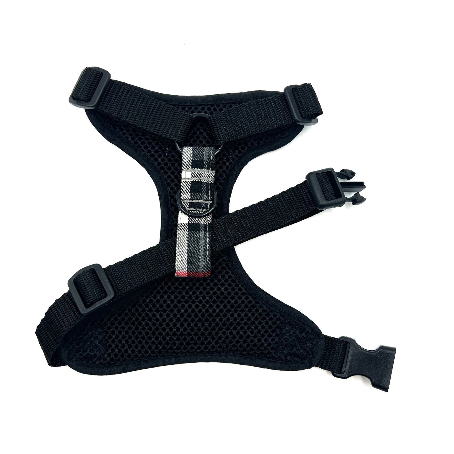 Black dog harness with a metal buckle on a white background