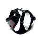 Black dog harness with a visible brand logo on a white background