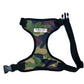 A camo print dog harness with adjustable straps and a metal d-ring, predominantly in green, brown, and black tones.