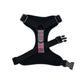 Black dog harness with a pink and gray pattern on a white background
