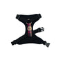Black dog harness with a colorful plaid strap on a white background