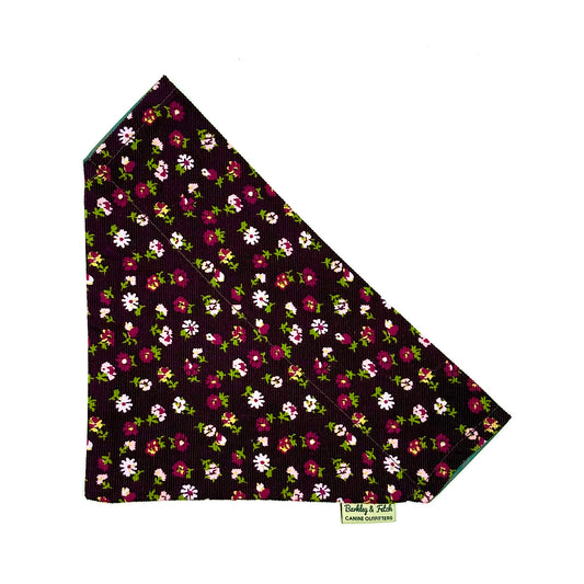 Floral patterned fabric on a black background with a visible brand logo.