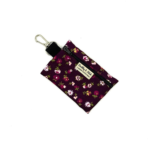 Floral patterned keychain pouch with a visible brand label on a white background